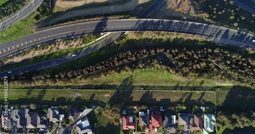 Vehicles moving in a single file toward the entrance to major carriage way of highway as seen from aerial perspective. photo