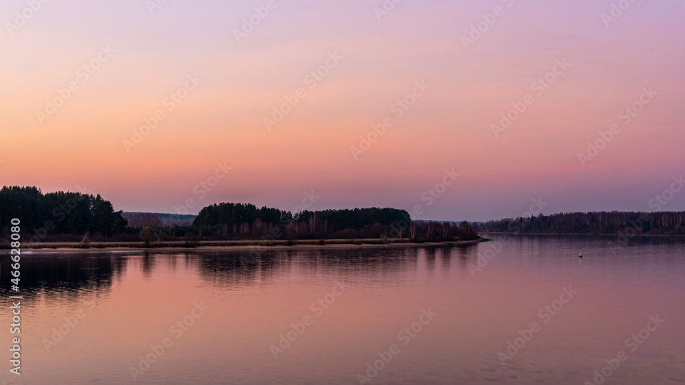 A beautiful view of the river from the high bank during sunset. Autumn landscape.