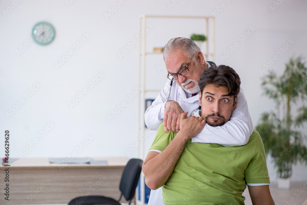 Young male patient visiting old male doctor Young male patient visiting old male doctor