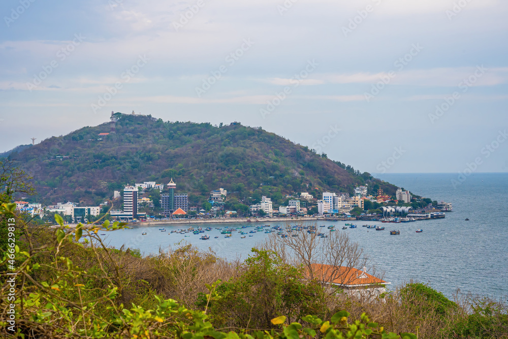 Panoramic coastal Vung Tau view from above, with waves, coastline, streets, coconut trees and Tao Phung mountain in Vietnam.