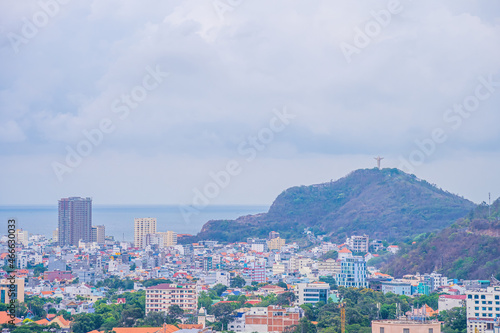 Panoramic coastal Vung Tau view from above, with waves, coastline, streets, coconut trees and Tao Phung mountain in Vietnam. © CravenA