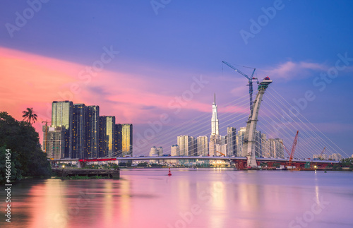 skyline with landmark 81 skyscraper, a new cable-stayed bridge is building connecting Thu Thiem peninsula and District 1 across the Saigon River. © CravenA