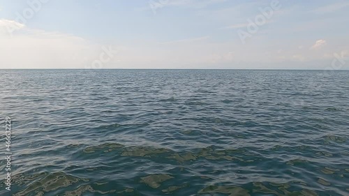 Flat horizon line on large body of water, lake or ocean, wispy cloud photo