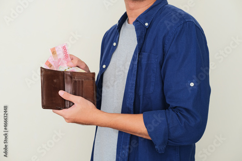 Cropped guy taking paper money from his wallet photo