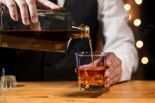 Bartender pouring Whiskey  on  bar 