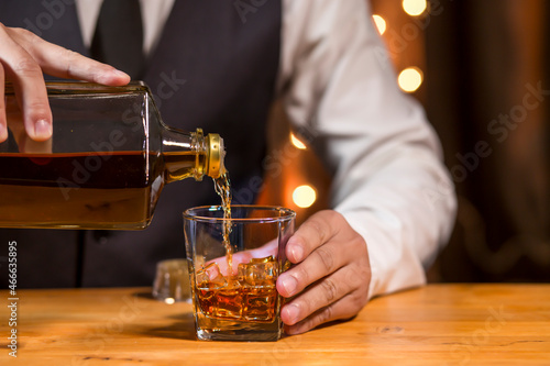 Bartender pouring Whiskey, on bar,