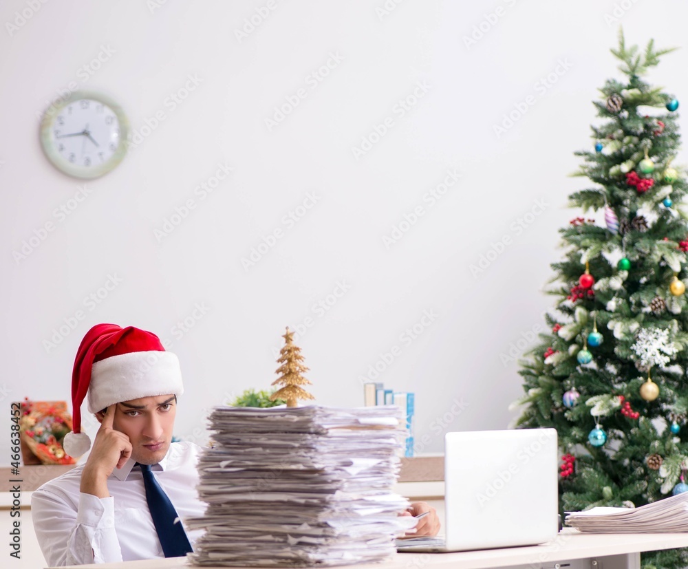 Young worker working in office on christmas shift Young worker working in office on christmas shift