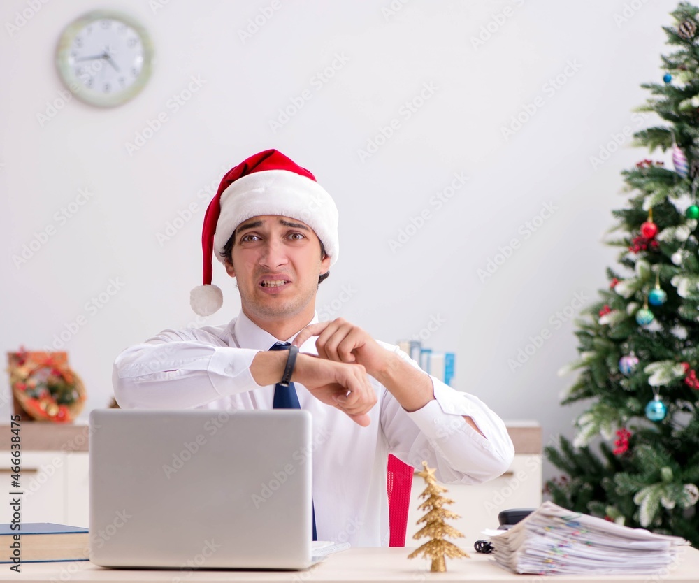 Young worker working in office on christmas shift Young worker working in office on christmas shift