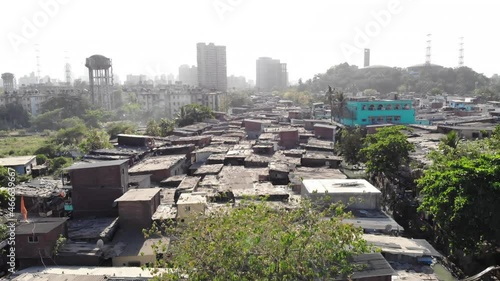 An aerial drone movement shot of the closely packed urban slums or shanty town housing situated in suburban part of the Mumbai city