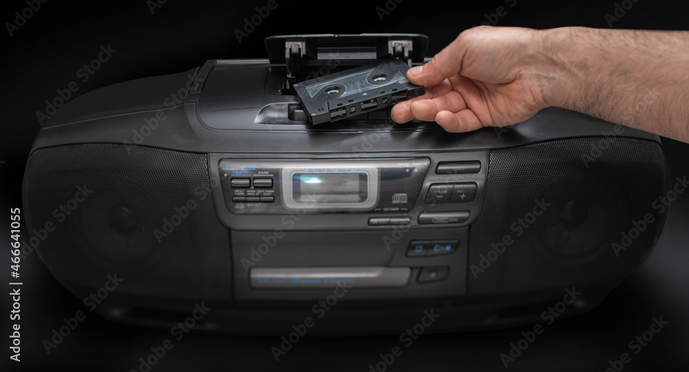 man puts a cassette in a tape recorder man puts a cassette in a tape recorder