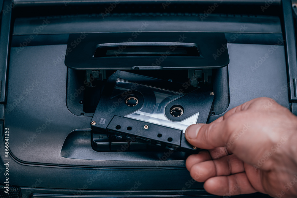 man puts a cassette in a tape recorder man puts a cassette in a tape recorder