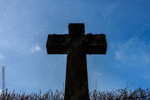 Large dark religious cross against a blue sunny sky