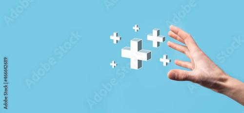 Hand hold 3D plus icon, man hold in hand offer positive thing such as profit, benefits, development, CSR represented by plus sign.The hand shows the plus sign