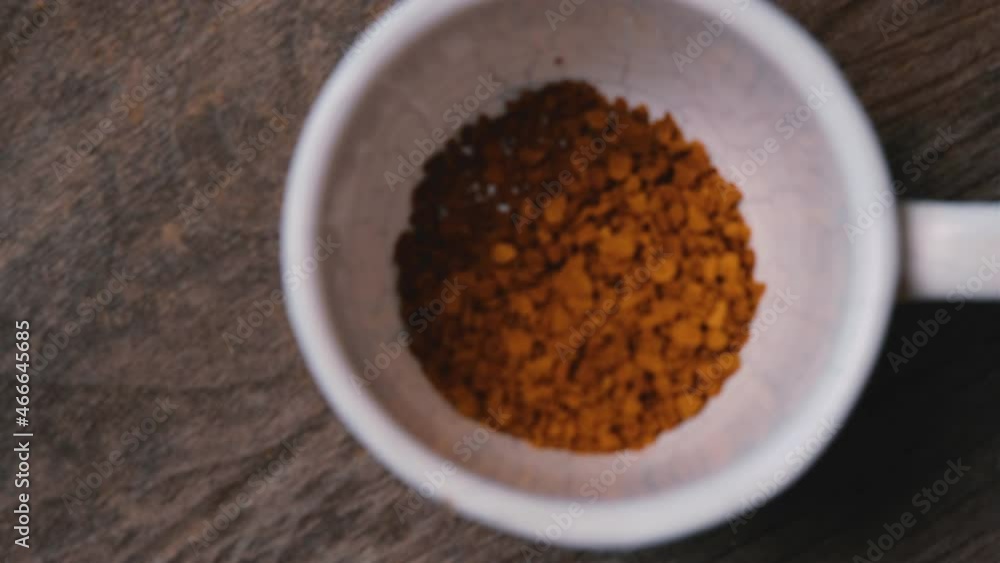 Top view Pouring instant coffee into coffee cup on wooden table and Pouring hot water mixing, Close-up and dolly out Top view Pouring instant coffee into coffee cup on wooden table and Pouring hot water mixing, Close-up and dolly out