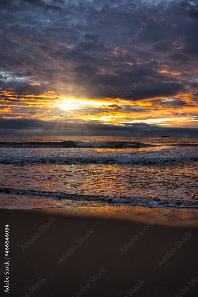 A beautiful and cloudy sunrise from the shore of a beach