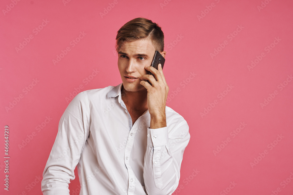 portrait of a man in a white shirt talking on the phone studio lifestyle portrait of a man in a white shirt talking on the phone studio lifestyle