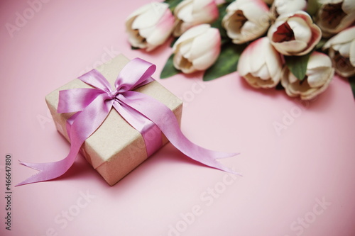 Gift boxes with pink ribbon and tulip flower bouquet on pink background © may1985
