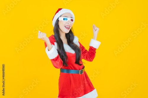 Portrait young asian woman wear christmas costume with action on yellow background © siraphol