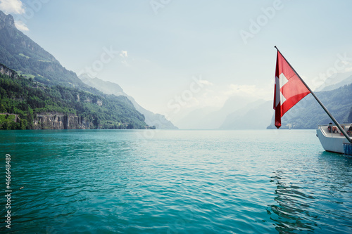 National flag of Switzerland with beautiful mountains and lake view.