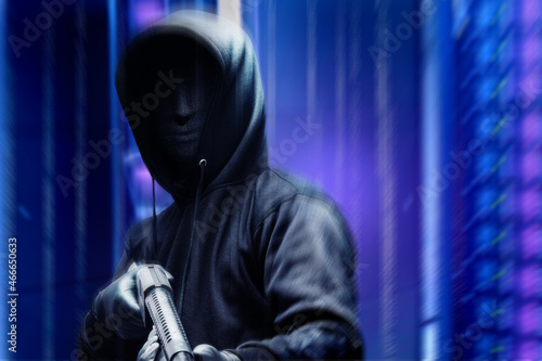 Criminal man in a hidden mask holding the shotgun while robbery