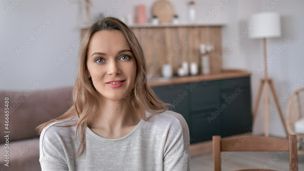 Closeup portrait of happy young blonde woman sitting at table kitchen living room relaxing at home Closeup portrait of happy young blonde woman sitting at table kitchen living room relaxing at home