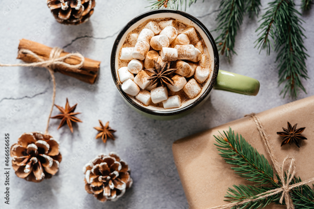 Christmas holiday creative layout with purple cup of marshmallow hot chocolate, pine tree, and pine cones Christmas holiday creative layout with purple cup of marshmallow hot chocolate, pine tree, and pine cones
