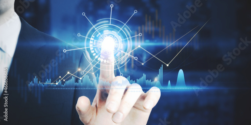 Businessman hand pointing at creative glowing business graph on blurry background. Innovation, information and statistics concept. Double exposure.
