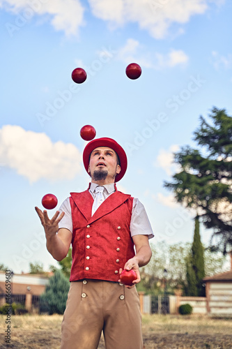 Man juggling balls in park photo