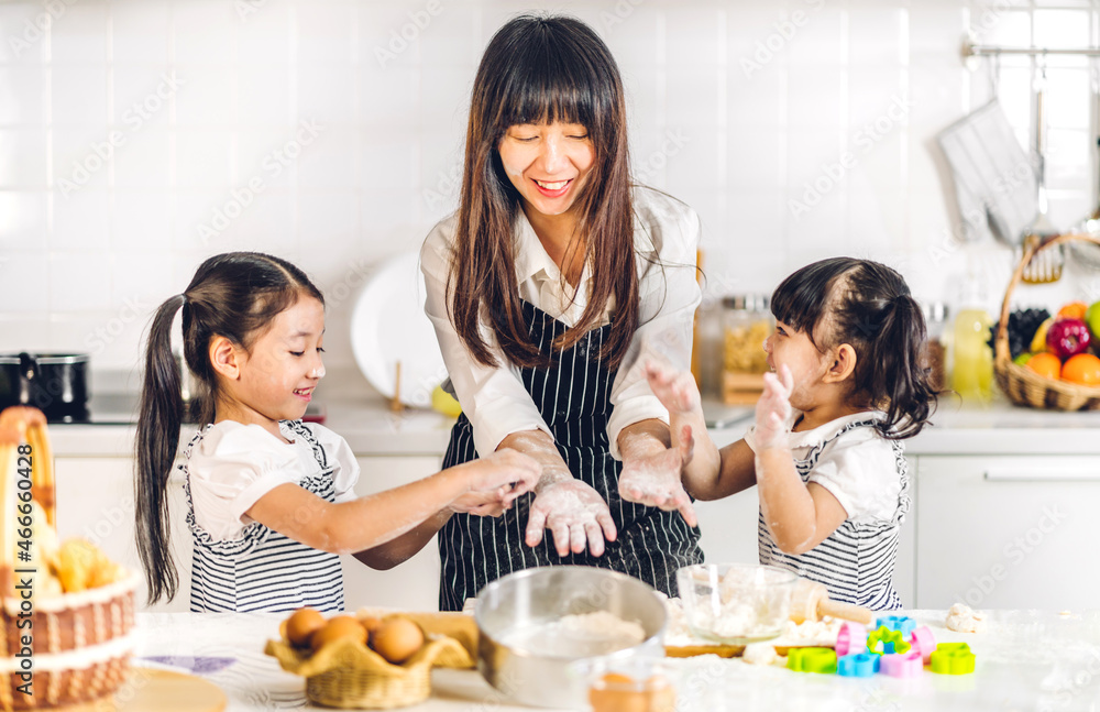 © Art_Photo - Portrait of enjoy happy love asian family mother and little toddler asian girl daughter child having fun cooking together with dough for homemade bake cookie and cake ingredient on table in kitchen © Art_Photo - Portrait of enjoy happy love asian family mother and little toddler asian girl daughter child having fun cooking together with dough for homemade bake cookie and cake ingredient on table in kitchen