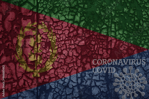 flag of eritrea on a old metal rusty cracked wall with text coronavirus, covid, and virus picture. © luzitanija