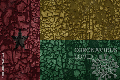 flag of guinea bissau on a old metal rusty cracked wall with text coronavirus, covid, and virus picture.