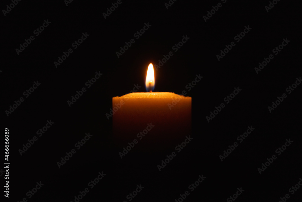 One single light candle burning brightly in the black background.Spiritual candle yellow flame. Flame of candle in the darkness.Copy space. One single light candle burning brightly in the black background.Spiritual candle yellow flame. Flame of candle in the darkness.Copy space.