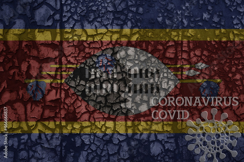 flag of swaziland on a old metal rusty cracked wall with text coronavirus, covid, and virus picture.