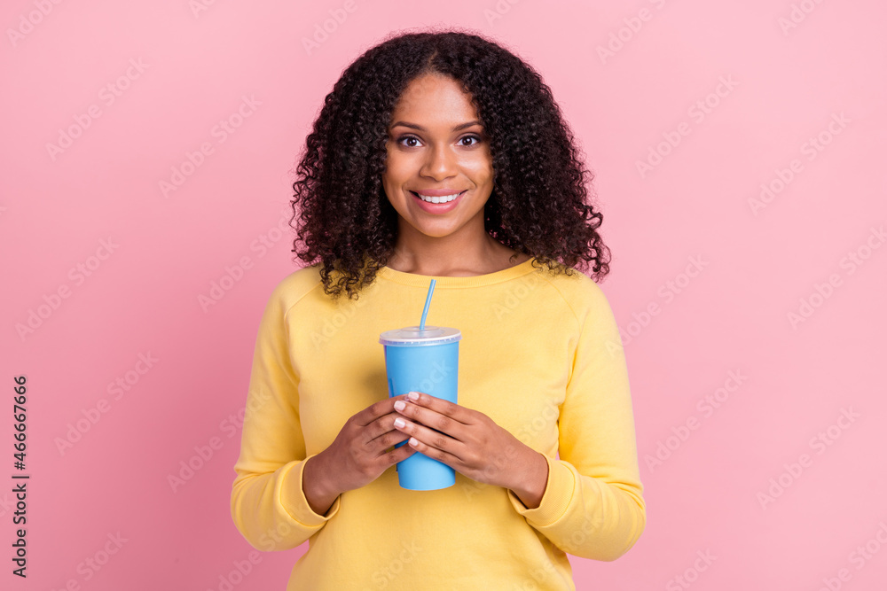 Photo of funny charming dark skin girl dressed yellow pullover holding soda smiling isolated pink color background Photo of funny charming dark skin girl dressed yellow pullover holding soda smiling isolated pink color background