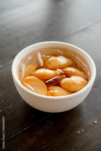 Close-up A bowl of Sala seedless in syrup with ice on the wood table.