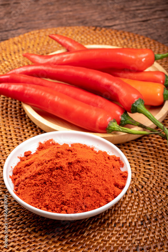 Korean pepper powder and red pepper in wooden plate, Korean chili powder on wooden table background