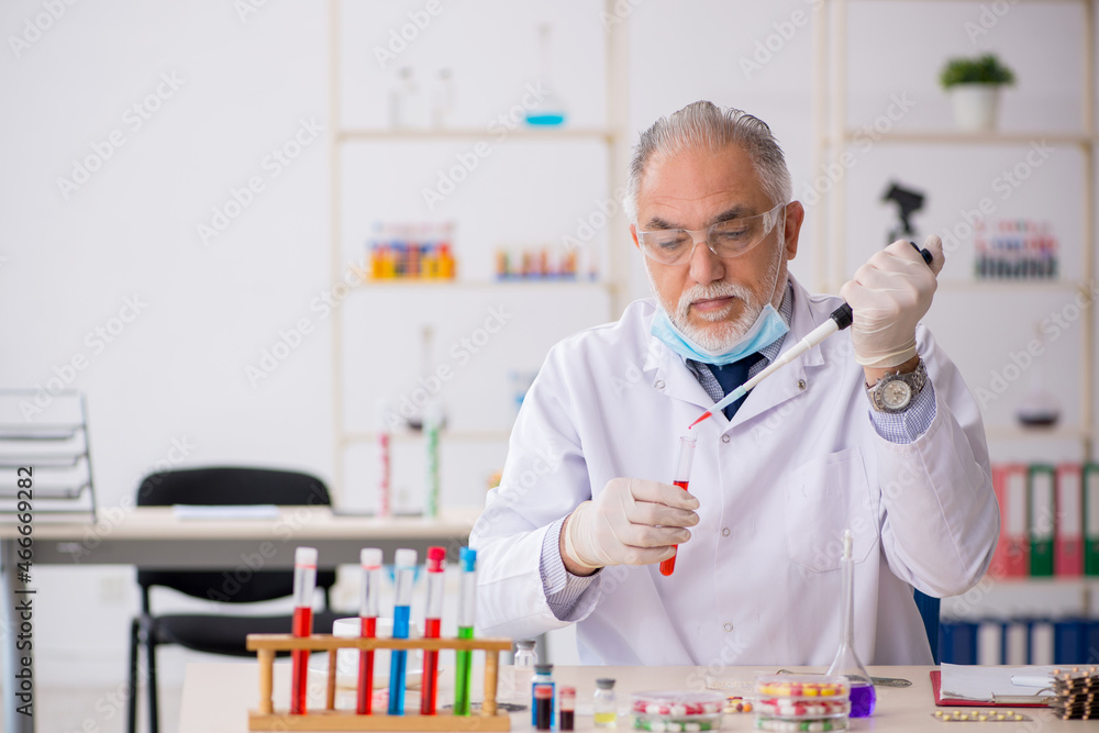 Old male chemist in drug synthesis concept Old male chemist in drug synthesis concept