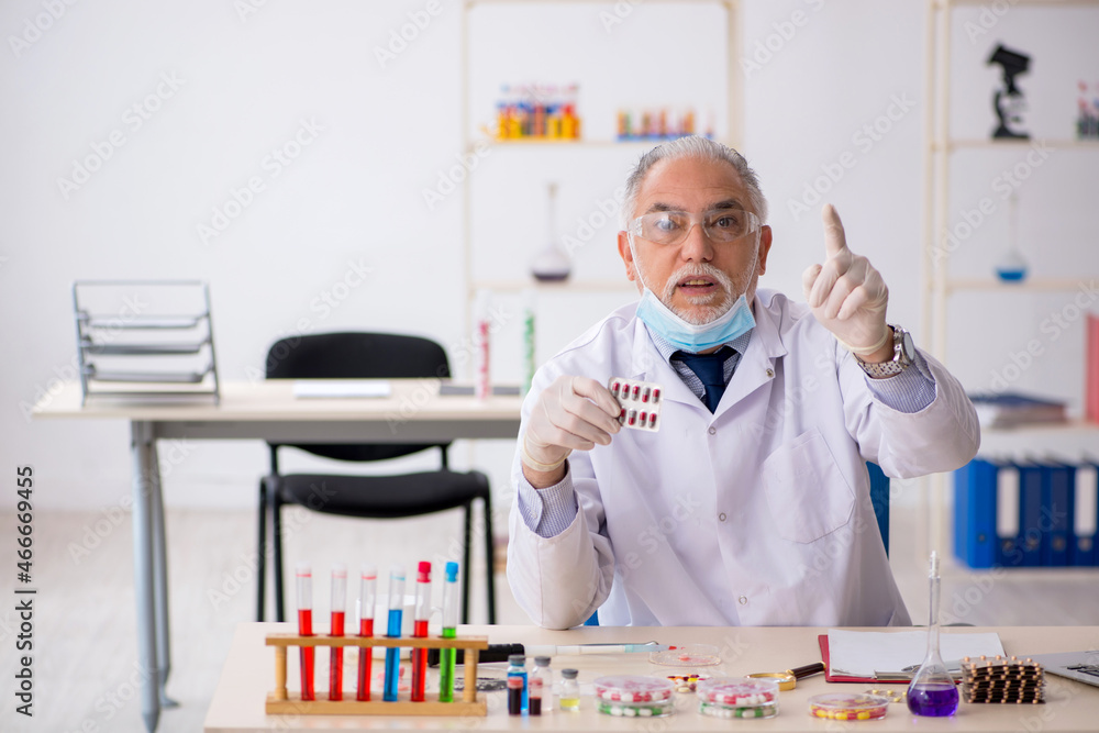 Old male chemist in drug synthesis concept Old male chemist in drug synthesis concept