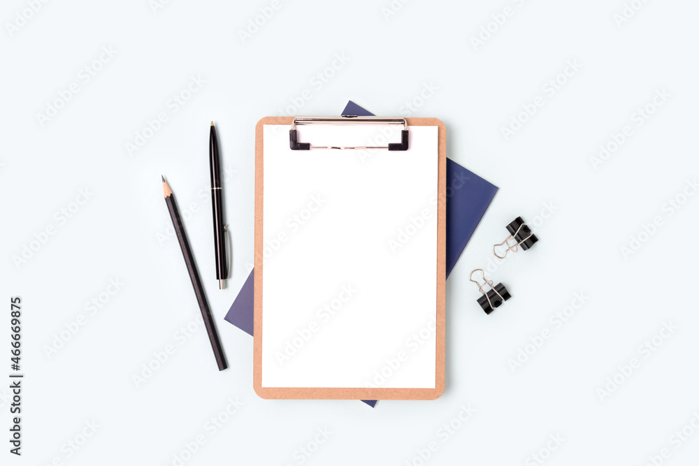 Clipboard with blank paper sheet mockup and stationery on a blue background. Workspace for education. Clipboard with blank paper sheet mockup and stationery on a blue background. Workspace for education.