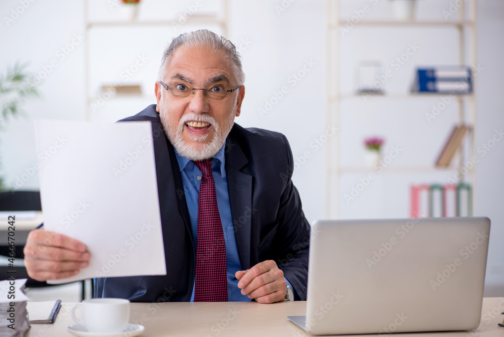 Old male employee working in the office Old male employee working in the office