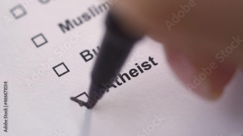 The person marks the atheist item in the list with a tick. Close-up. Questionnaire.