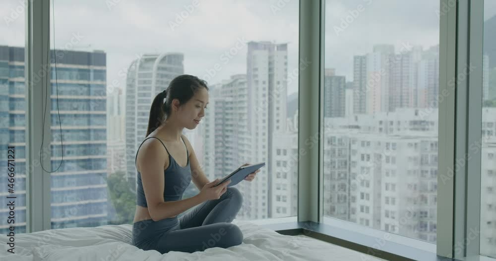 Woman look at tablet computer and sit beside window Woman look at tablet computer and sit beside window