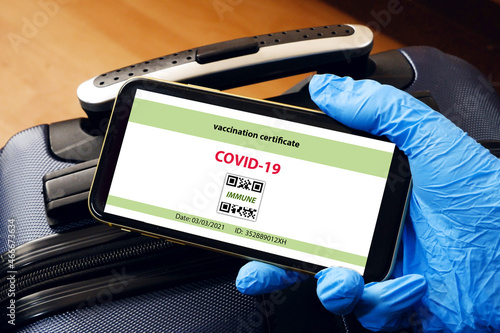 Vaccination passport on a mobile phone allowing travel in hand. Vaccination against the coronavirus Covid 19.Imunity or Health passport photo