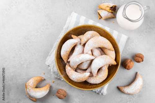 Breakfast with homemade crescents stuffed with walnuts and choccolate, milk. On the light grey table. Copy space.