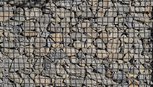 A fence made of natural stone, crushed stone, granite.