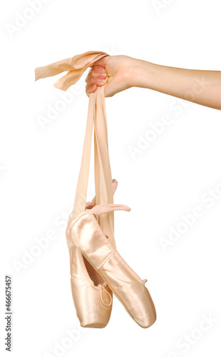 ballet shoes Hanging by a woman's hand isolated in front of white background photo