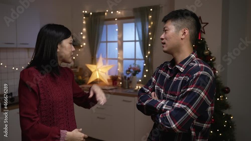 slow motion of asian married couple yelling at each other with gesture while they are arguing over misunderstanding in a decorated home interior on Christmas eve.