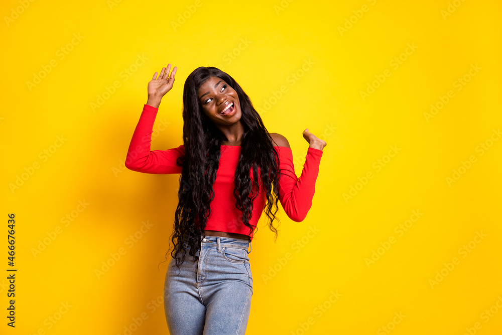 Portrait of attractive carefree cheerful wavy-haired girl dancing having fun celebrating isolated over bright yellow color background Portrait of attractive carefree cheerful wavy-haired girl dancing having fun celebrating isolated over bright yellow color background