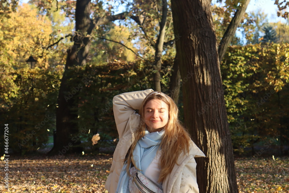 a young girl whirls in the park in late autumn, splashing in the last sun among the falling yellow foliage a young girl whirls in the park in late autumn, splashing in the last sun among the falling yellow foliage