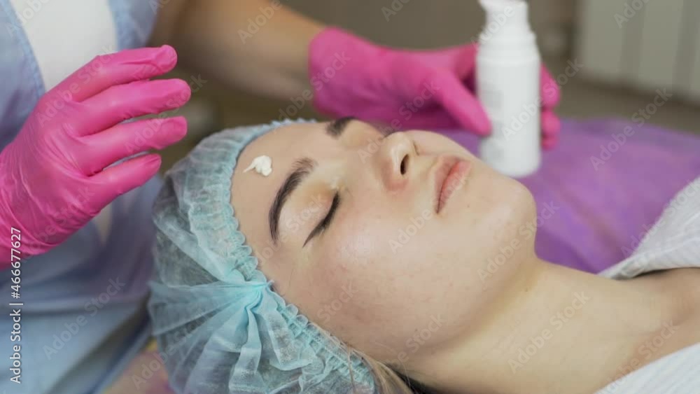 Facial Skin Care. Professional Applies Nourishing Face Cream to Attractive Girl and Massages Facial Skin in the Spa Beauty Salon. Facial Skin Care. Professional Applies Nourishing Face Cream to Attractive Girl and Massages Facial Skin in the Spa Beauty Salon.